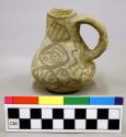 Ceramic jug, one handle, brown on white exterior design.