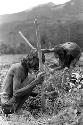 Samuel Putnam negatives, New Guinea; an old man and woman working in the fields in front Homoak