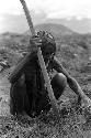 Samuel Putnam negatives, New Guinea; an old man digging in the field; net over his head