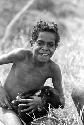 Samuel Putnam negatives, New Guinea; Weneluke playing with a small, black puppy; it is Wisa - the puppy that PM owns now