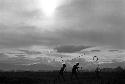 Samuel Putnam negatives, New Guinea; boys silhouetted; playing sikoko wasin; in the distance; spear in the air; also a hoop