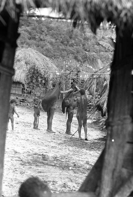 Samuel Putnam negatives, New Guinea; tilting shot into Wuperainma I; women with their sus