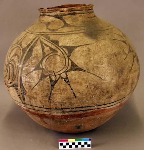 Pottery storage jar. Globular, reddish base, cream slip with black design