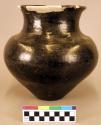 Pottery jar. Conical shaped body, tall and somewhat flaring rim which has been