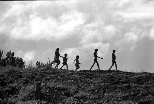 Samuel Putnam negatives, New Guinea people walking along a ridge