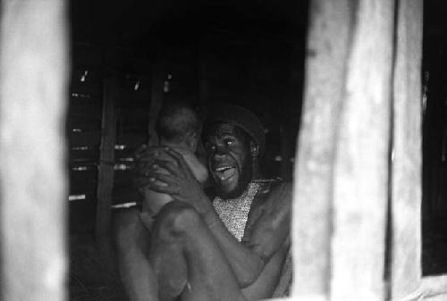 Samuel Putnam negatives, New Guinea; Wali smiles at his baby; seen thru the hunu door