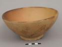 Ceramic bowl, footed; rimless; painted swirl and other pattern on exterior; painted lip