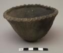 Small black bowl, crimped rim, incised symbol inside; bowl possibly signed on bottom