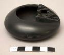 Small black pot with modeled adobe wall; hairline crack; tiny chip at top of wall
