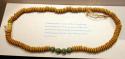 Necklace of disc-shaped yellow beads w/ several round yellow and green beads