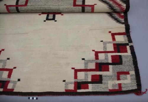 Navajo rug with triangular designs, white background, gray, black, red wool