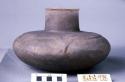 Ceramic complete vessel, medium neck, flared rim, raised design at shoulder