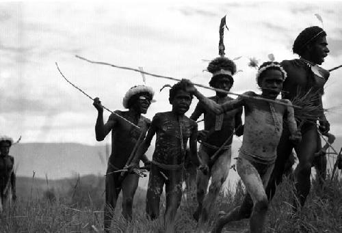 Samuel Putnam negatives, New Guinea; boys and men running in circles halfway between Puakoloba and the Anelerak