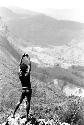 Samuel Putnam negatives, New Guinea; young man looking towrds the Solimo; hands above head; valley stretching out below him