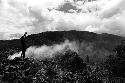 Samuel Putnam negatives, New Guinea; scenic shot;  a boy with fire going in the right middleground