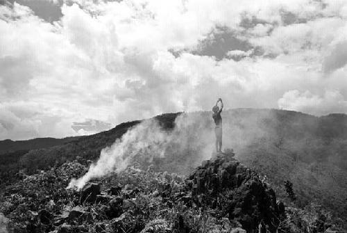 Samuel Putnam negatives, New Guinea; scenic shot; with a boy standing next to smoke coming from a fire