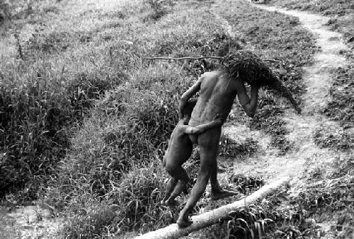 Samuel Putnam negatives, New Guinea; a little boy and a man crossing a foot bridge across a garden ditch