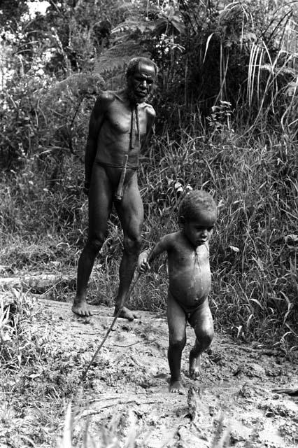 Samuel Putnam negatives, New Guinea; Haliole and little boy coming along very muddy path near Apulek