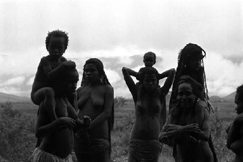 Samuel Putnam negatives, New Guinea; a group of women and children; some on the shoulders of the girlsand women; outside the sien forest at Homoak