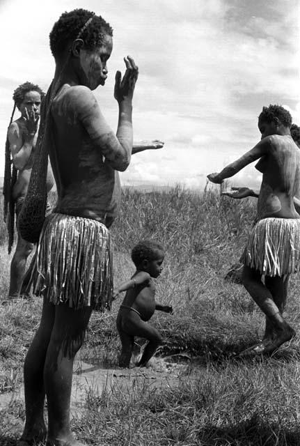 Samuel Putnam negatives, New Guinea; 2 little girls putting clay on; one looks at the camera