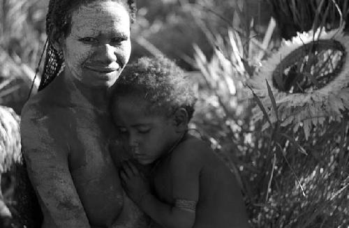 Samuel Putnam negatives, New Guinea; a woman and a child asleep at her breast; she is self conscious