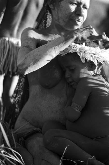Samuel Putnam negatives, New Guinea; a woman fixes a kaia kara on a little boy's head