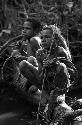 Samuel Putnam negatives, New Guinea; Okal and Isile perched on a log near the Elokhere River; equipped to play sikoko wasin; these are twin boys