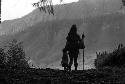 Samuel Putnam negatives, New Guinea; woman and child; silhouette- walking out onto the lighter part near the woods that go down to the Elokhere