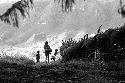 Samuel Putnam negatives, New Guinea; woman and child; silhouette- walking out onto the lighter part near the woods that go down to the Elokhere