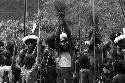 Samuel Putnam negatives, New Guinea; man singing in the middle of a group of about 20 boys and men