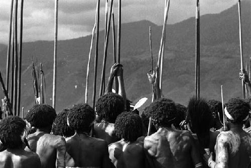 Samuel Putnam negatives, New Guinea; from behind men's group, head and shoulders and spears