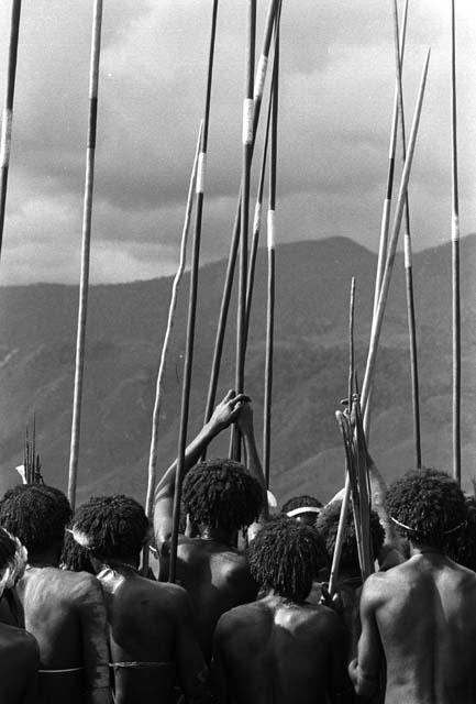 Samuel Putnam negatives, New Guinea; from behind men's group, head and shoulders and spears