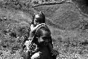 Samuel Putnam negatives, New Guinea; woman looking at the camera with a child on her shoulder