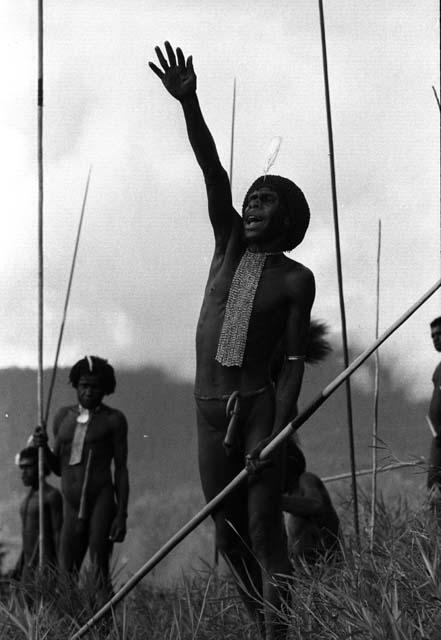 Samuel Putnam negatives, New Guinea; a man shouts toward the enemy; raises his right hand