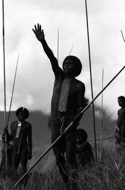 Samuel Putnam negatives, New Guinea; a man shouts toward the enemy; raises his right hand