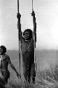 Samuel Putnam negatives, New Guinea; a warrior propped up between his 2 spears; looks attentively toward the enemy