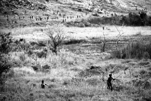 Samuel Putnam negatives, New Guinea; men in frgd; running back towards the WW; Wittaia going home in t he far distance