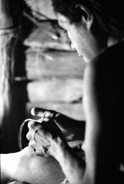 Samuel Putnam negatives, New Guinea; woman working on something inside of a lise