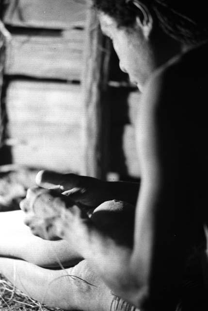 Samuel Putnam negatives, New Guinea; woman working on something inside of a lise