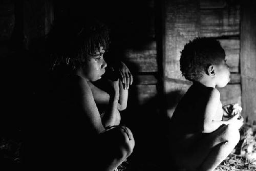 Samuel Putnam negatives, New Guinea; 2 children eating in hunu at night