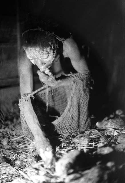 Samuel Putnam negatives, New Guinea; a woman throwing things into her su from the hakse