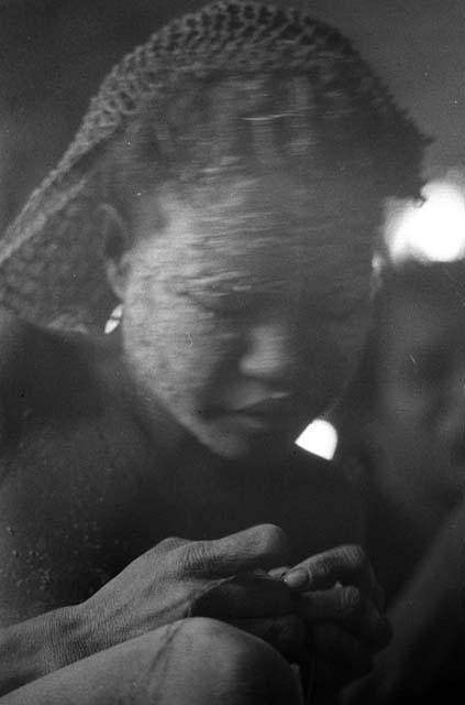 Samuel Putnam negatives, New Guinea; woman working on something in hunu