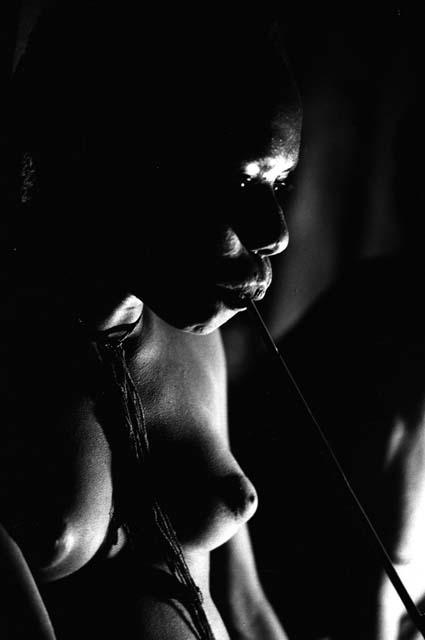 Samuel Putnam negatives, New Guinea; woman smoking inside hunu