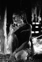 Samuel Putnam negatives, New Guinea; woman smoking with a long reed cigar holder in a hunu in Wuperainma
