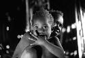 Samuel Putnam negatives, New Guinea; child looks at the camera; woman behind him