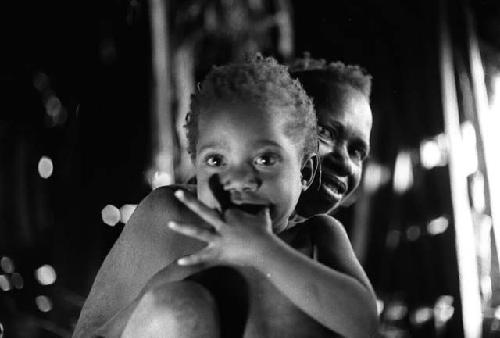 Samuel Putnam negatives, New Guinea; child looks at the camera; woman behind him