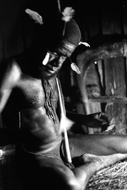 Samuel Putnam negatives, New Guinea; Wali in his honai in Lokoparek; putting feathers into his hair net