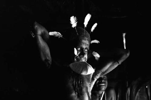 Samuel Putnam negatives, New Guinea; Wali in his honai at Lokoparek putting his mikak around his neck