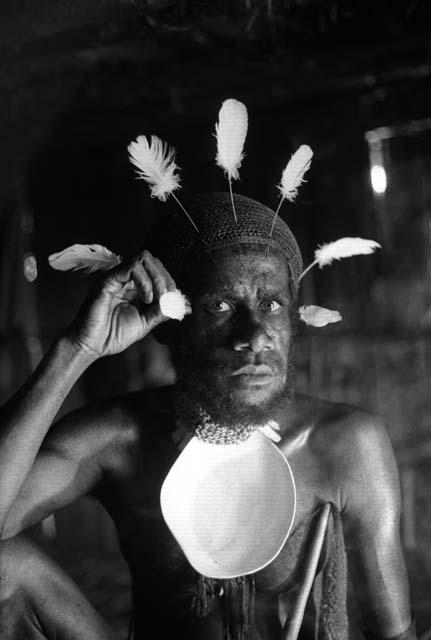 Samuel Putnam negatives, New Guinea; Wali adjusting feathers in his head