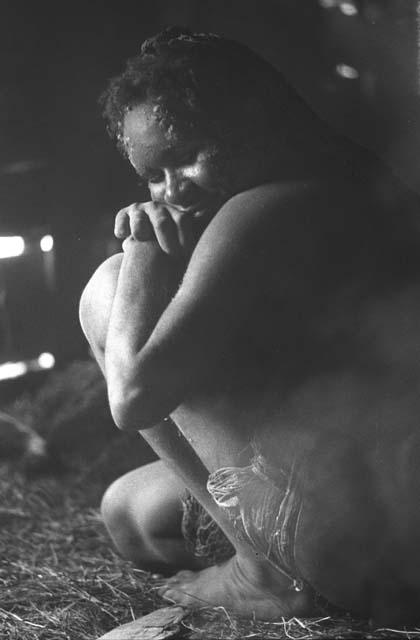 Samuel Putnam negatives, New Guinea; a woman rests on her knees; inside a hunu